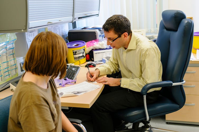 GP writes script for patient.