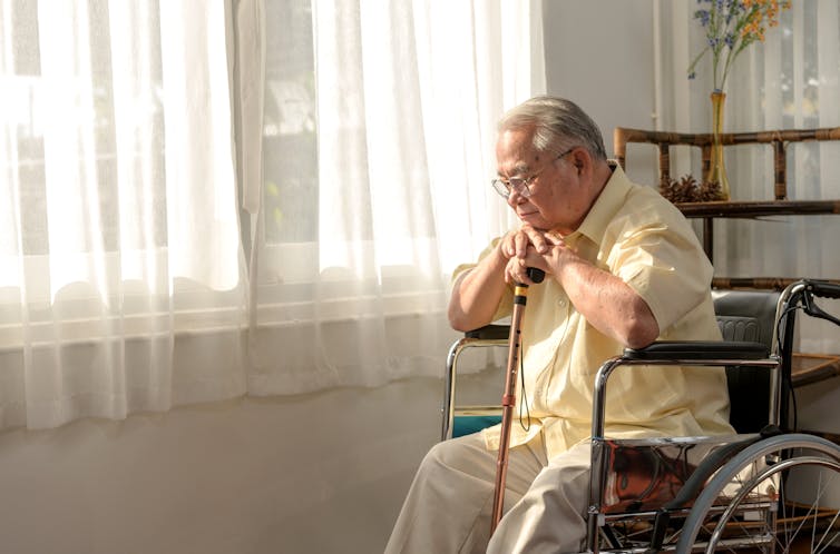 Older man sits in living room in a wheelchair