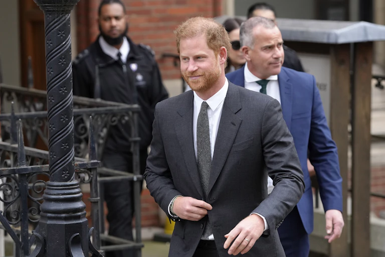 Prince Harry walking out of a brick building