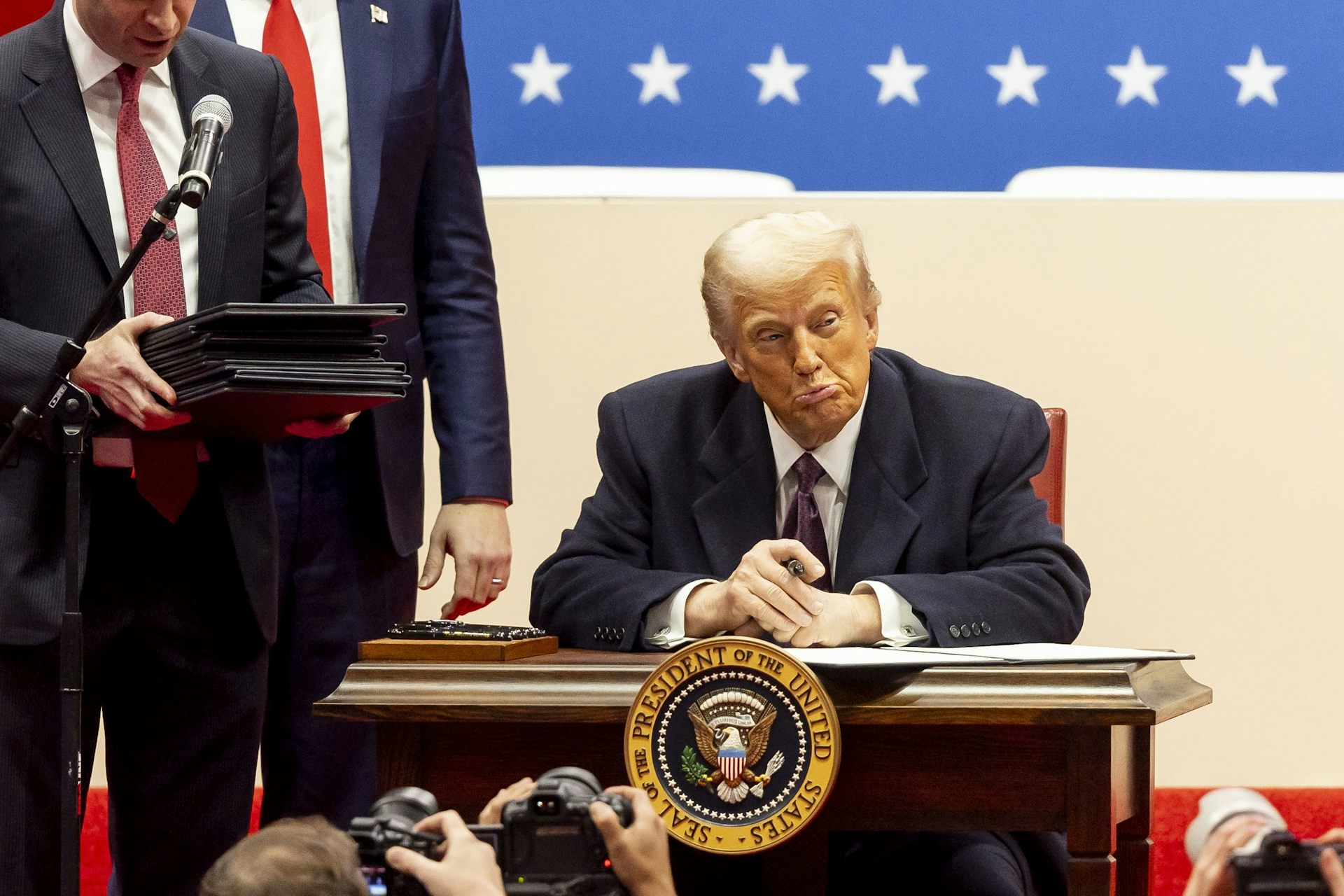 Donald Trump signs a series of executive actions on stage during a presidential inaugural event at the Capitol One Arena in Washington, DC, USA, 20 January 2025.