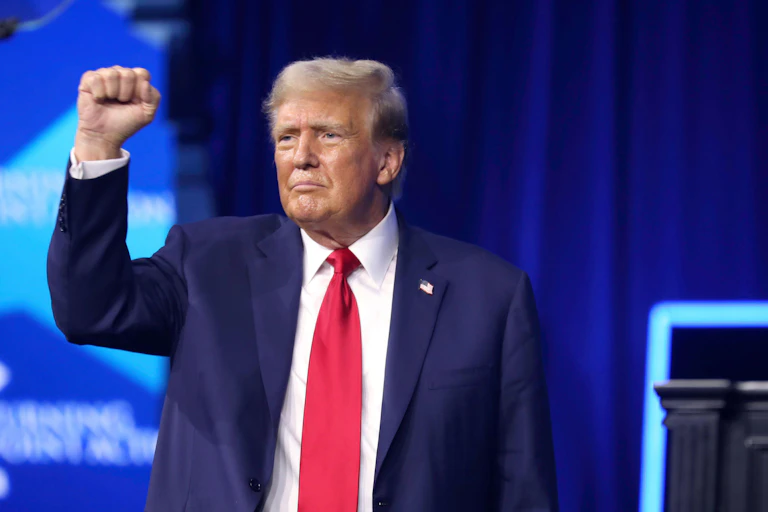 Donald Trump with arm raised.