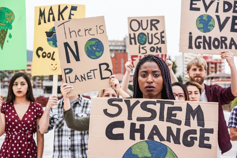 climate protestors holding banners, system change, there si no planet B