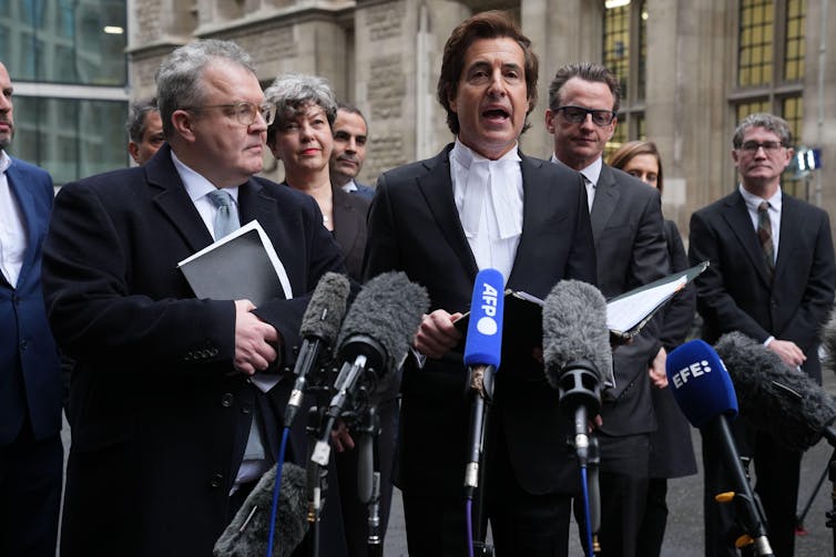David Sherborne speaking into a group of microphones outside the court
