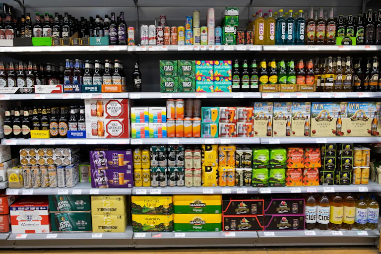 Rows of alcoholic drinks on supermarket shelves.