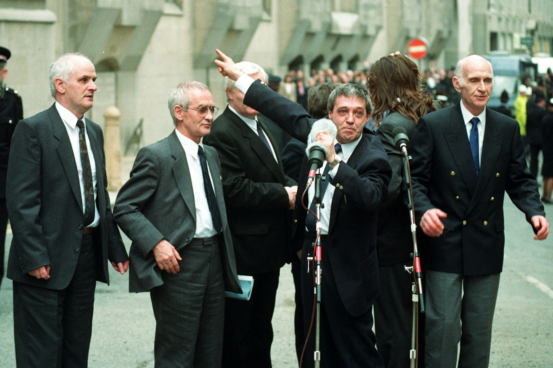 The Birmingham Six gathered around microphones in front of the old bailey