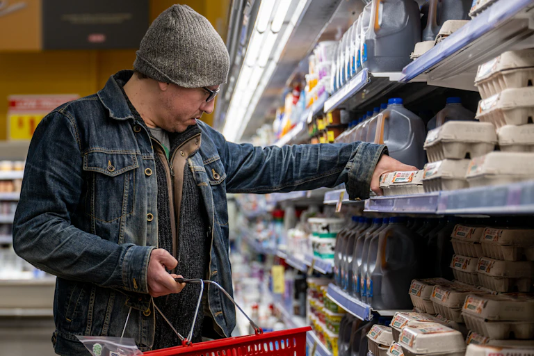 A customer shops for eggs at a grocery store.