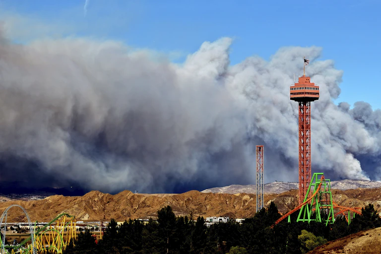A red tower in front of a huge plume of smoke