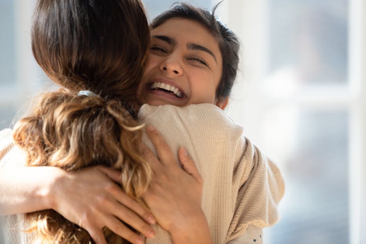 Two young women hugging