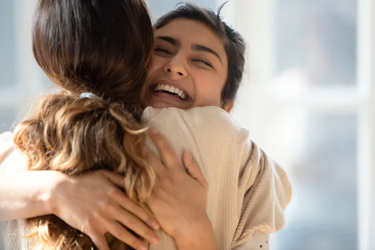 Two young women hugging
