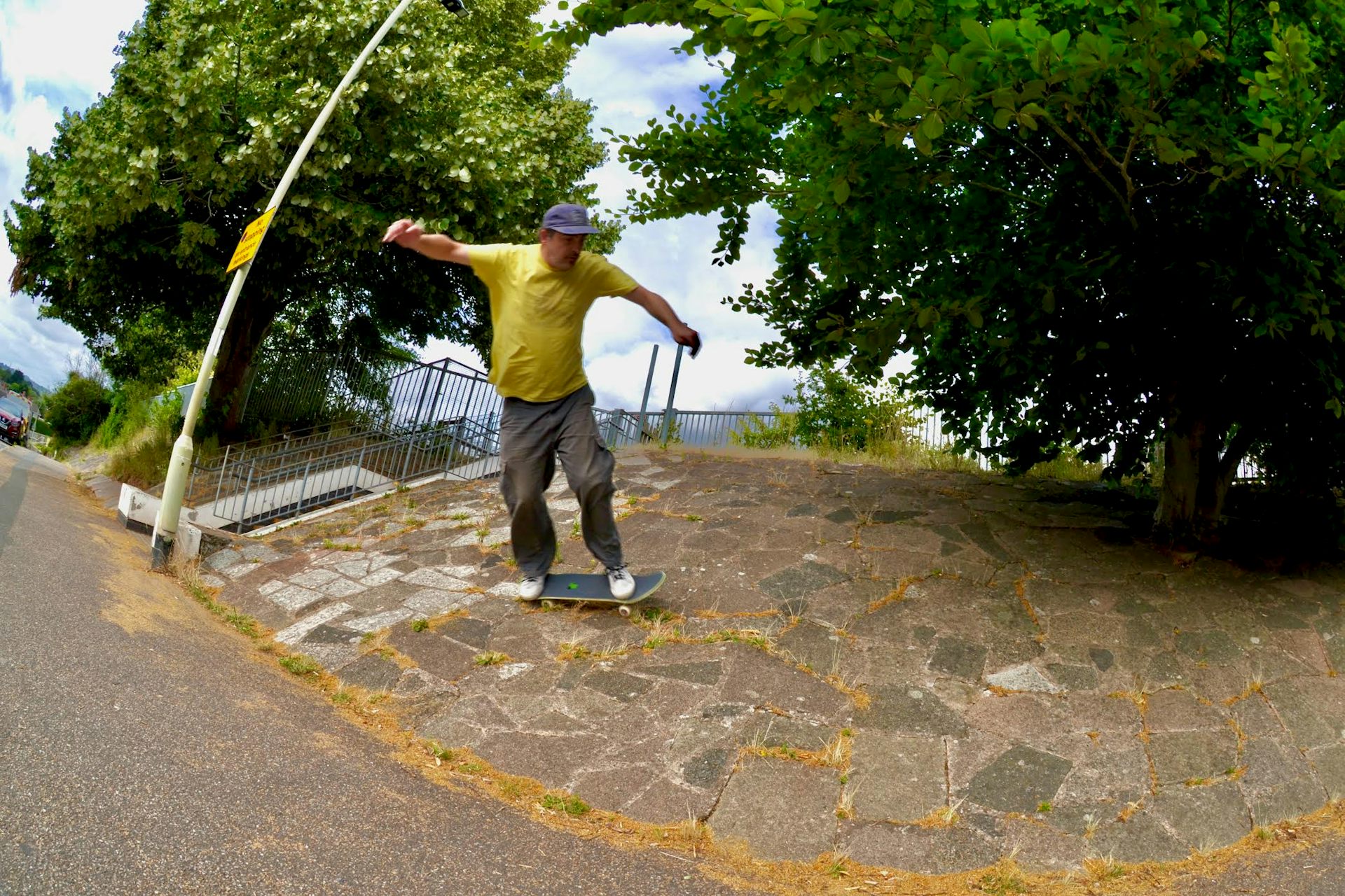 Man in a yellow T-shirt skateboarding