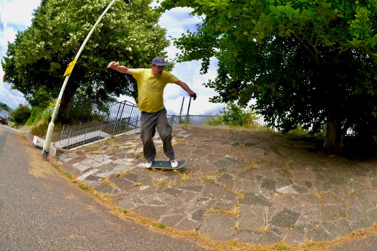 The sound of skateboarding gives skaters a healing method to connect to town 2 Man in a yellow T-shirt skateboarding