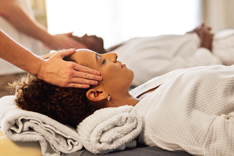 A couple getting a temple massage at a spa.