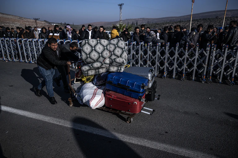 A man pushes a trolley laden with luggage.