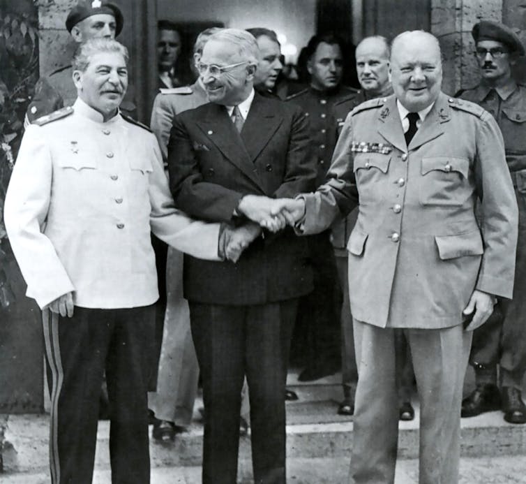 Harry Truman shaking hands with Joseph Stalin and Winston Churchill.