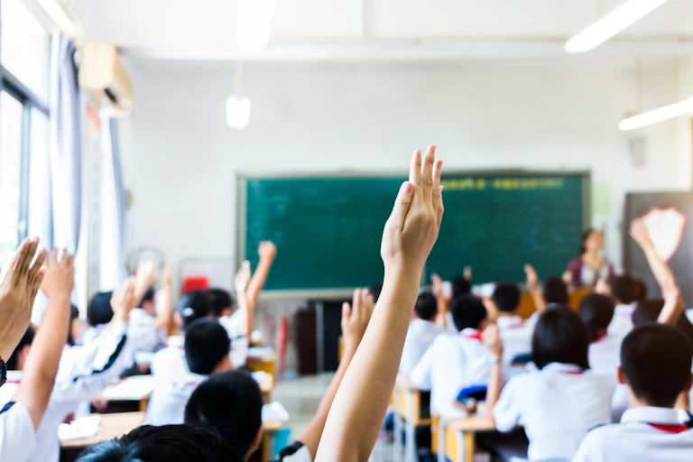 children raise hands in class