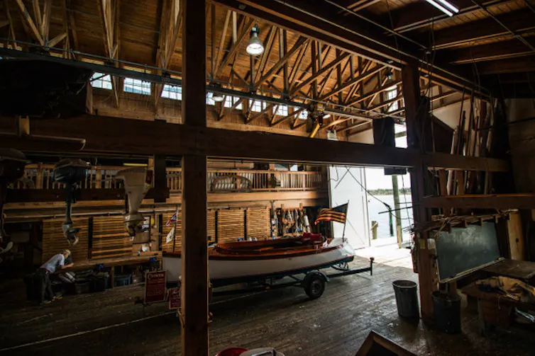 A boathouse with a boat bearing a US flag.