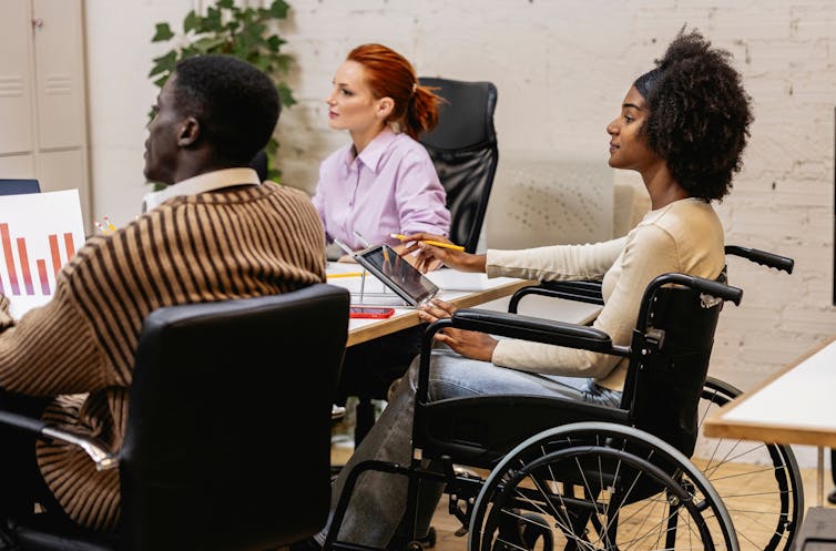 woman using a wheelchair at a business meeting with colleagues
