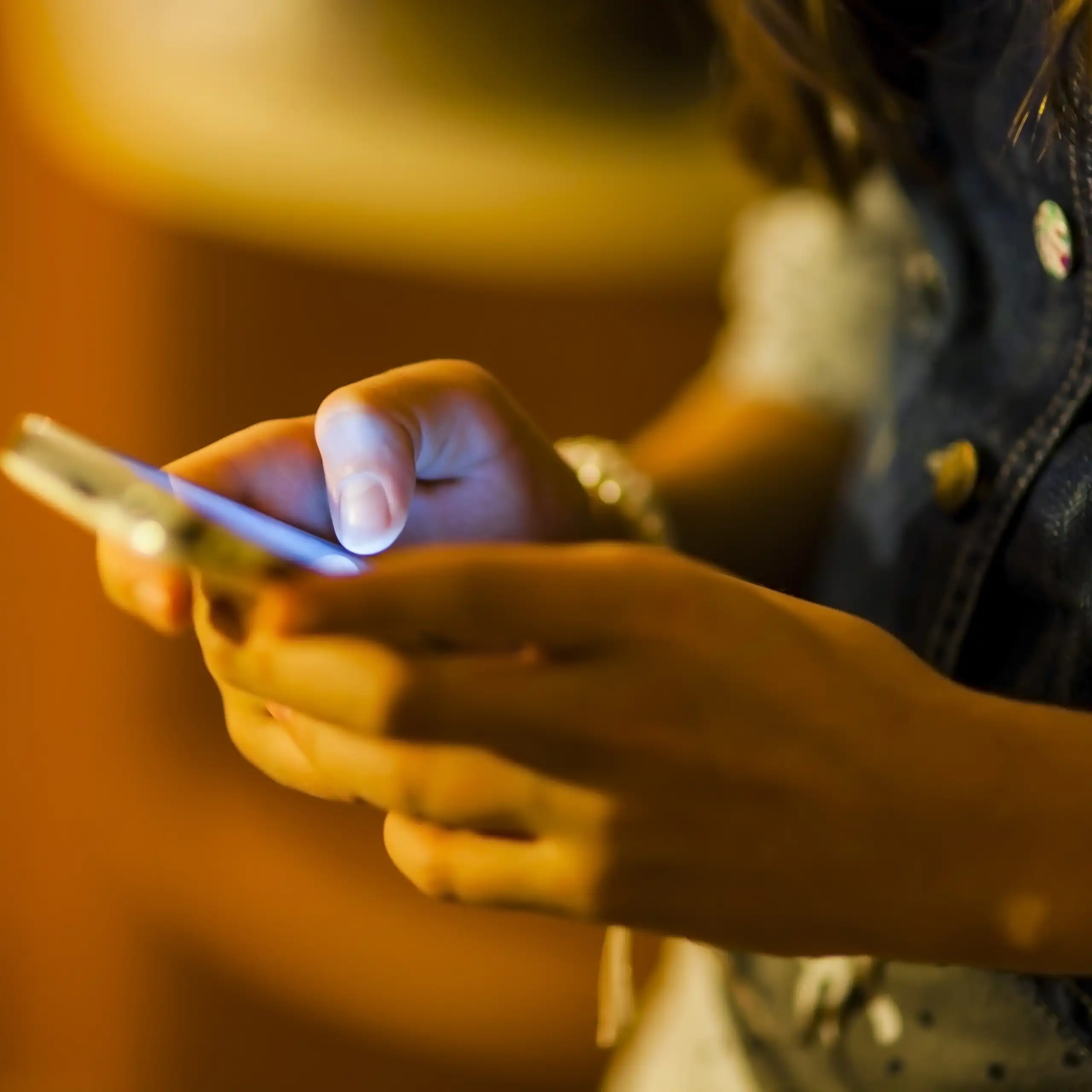 A young person holds a phone.