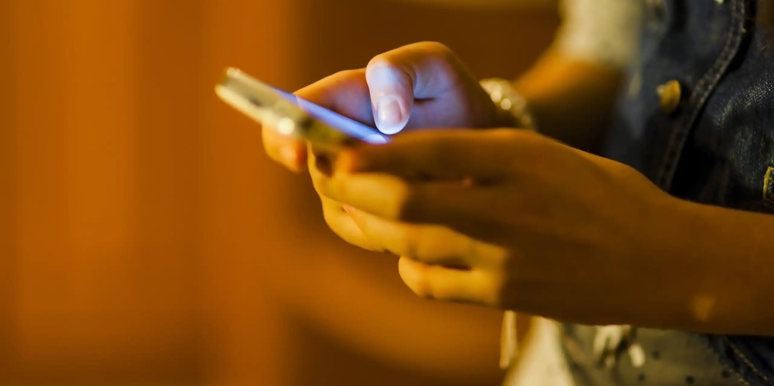 A young person holds a phone.