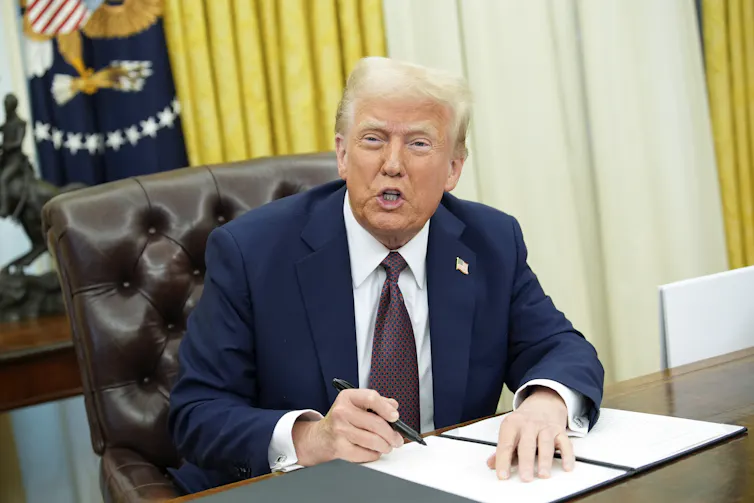 US President Donald Trump signs executive orders in the Oval Office of the White House