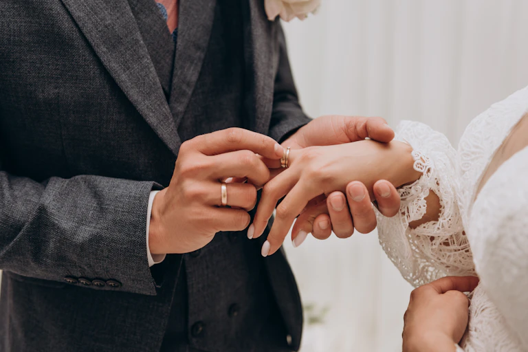 A man places a ring on a woman's finger