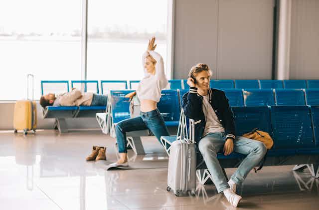 woman practicing yoga while waiting flight in airport terminal