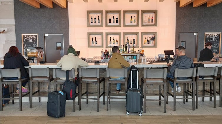 Passageiros sentados em um bar do aeroporto de Nova Orleans