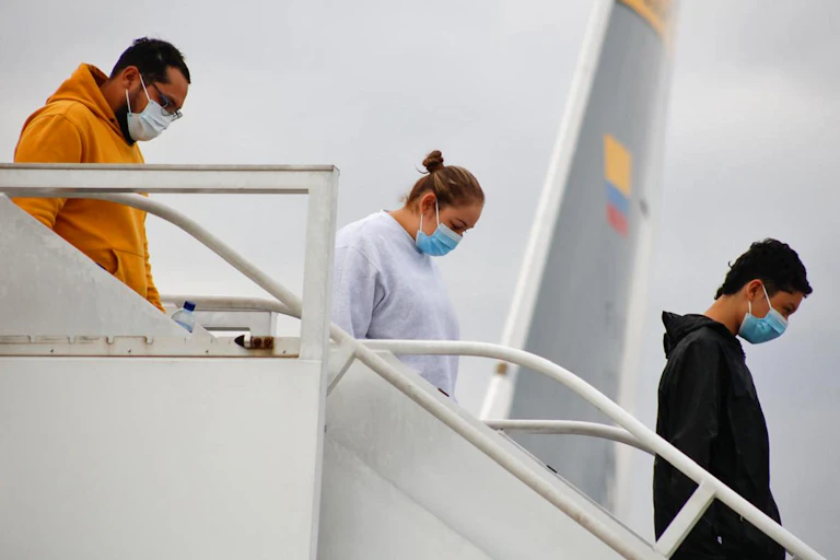 Three Colombian citizens walking off a plane.