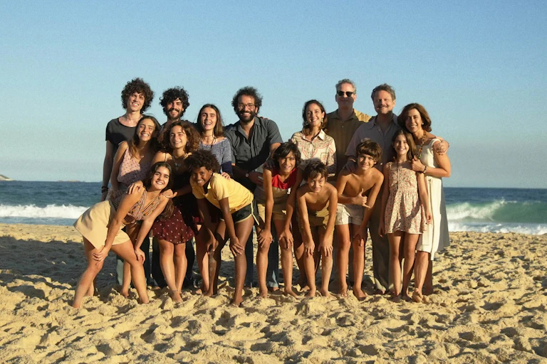 Una familia grande posa en la playa para una foto.