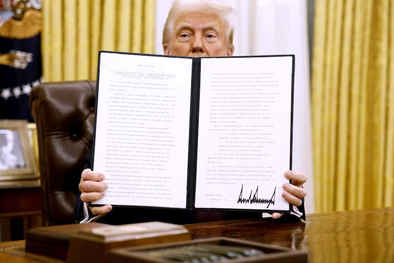 A man holds up a folder with pieces of paper in it.