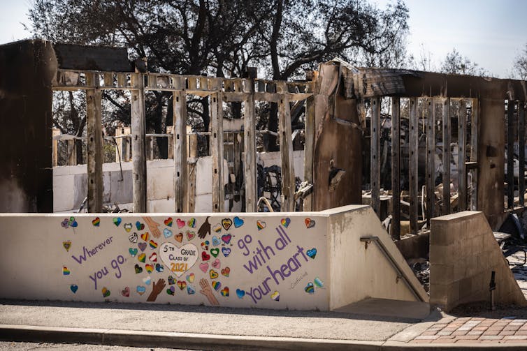 The frame of a school building is exposed after being burned by wildfires.