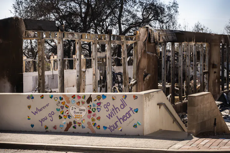 The frame of a school building is exposed after being burned by wildfires.