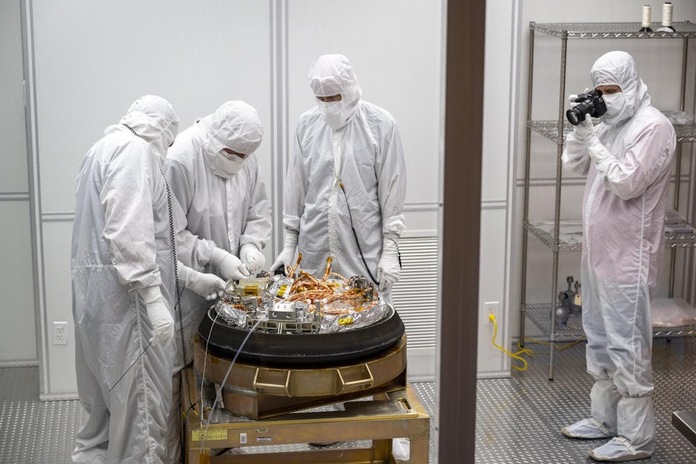 Equipes de curadoria processam a cápsula de retorno de amostra da missão OSIRIS-REx da NASA em uma sala limpa. Keegan Barber/NASA
