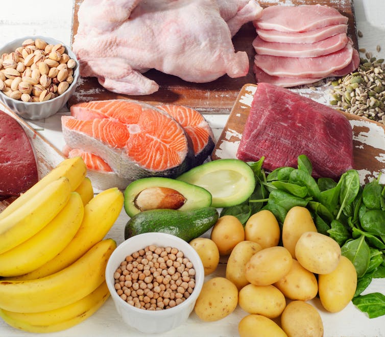 An array of vitamin-rich B6 foods including salmon, avocado, potatoes, spinach, chickpeas, banana and chicken.