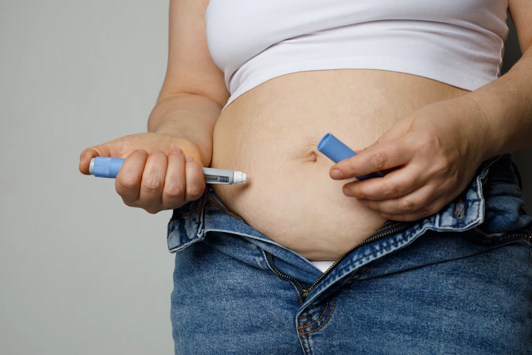 Une femme procède à une auto-injection d’Ozempic (semaglutide) dans son abdomen.