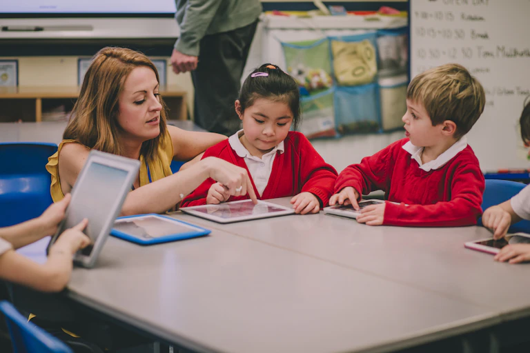 Teacher and primary age children with tablets in class