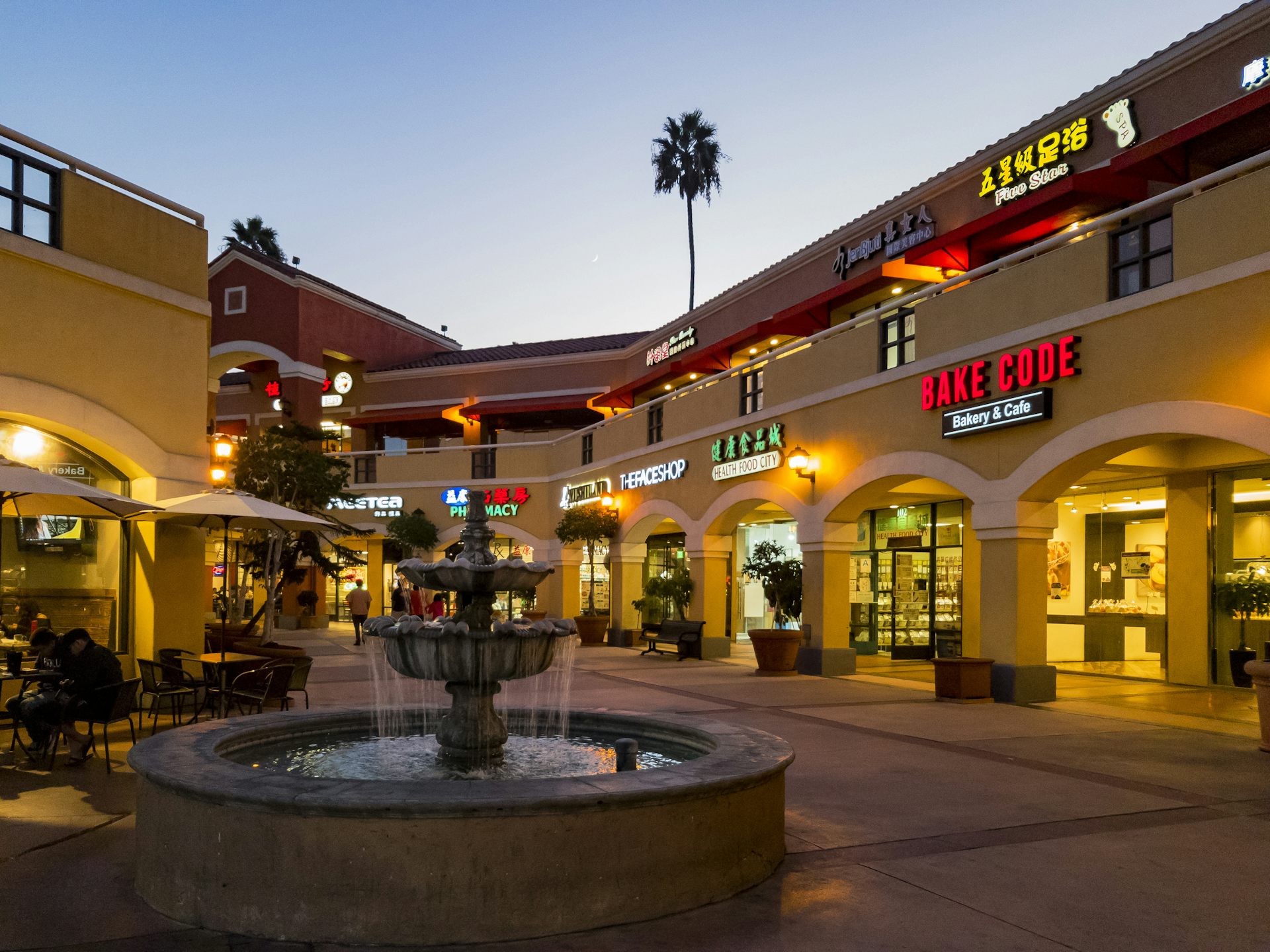 La foto del centro comercial exterior en el sur de California. Muchas tiendas delanteras incluyen la señalización de guiones asiáticos, y hay una palmera en el fondo.