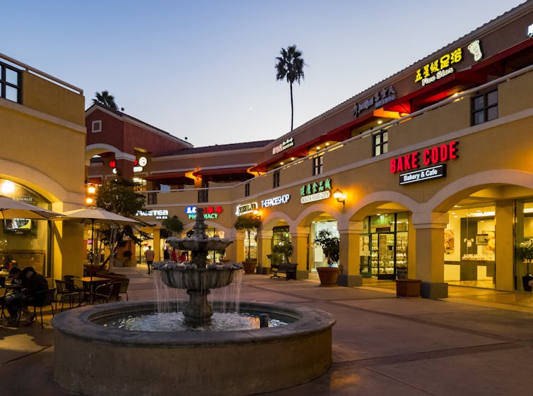 A medida que los inmigrantes asiáticos en los Estados Unidos se resistieron a asimilar, creando un suburbio estadounidense animado 5 La foto del centro comercial exterior en el sur de California. Muchas tiendas delanteras incluyen la señalización de guiones asiáticos, y hay una palmera en el fondo.