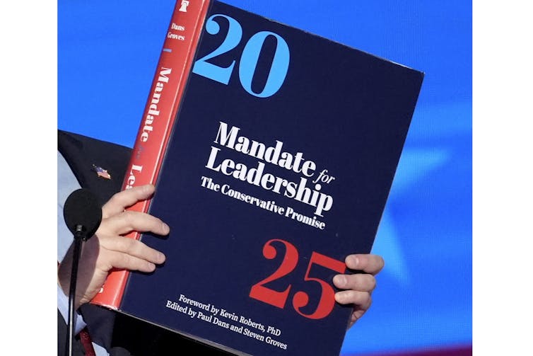 A large book with '2025' and 'Mandate for Leadership' printed on its cover.