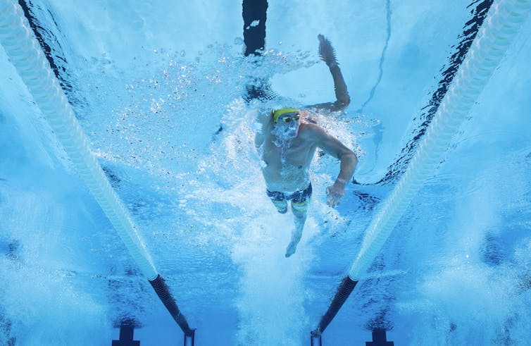 Swimmer with amputated leg competing in a pool.