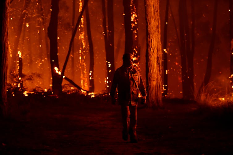 man walks near bush fire
