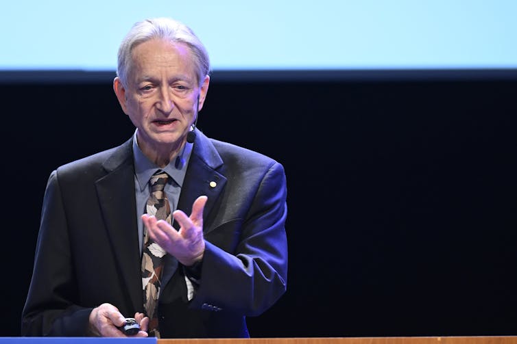 Photo of a man in a suit giving a speech.