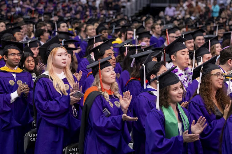 Graduates in robes standing in a group.