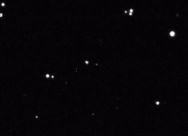 Video showing a faint dot in the middle of a background of moving stars