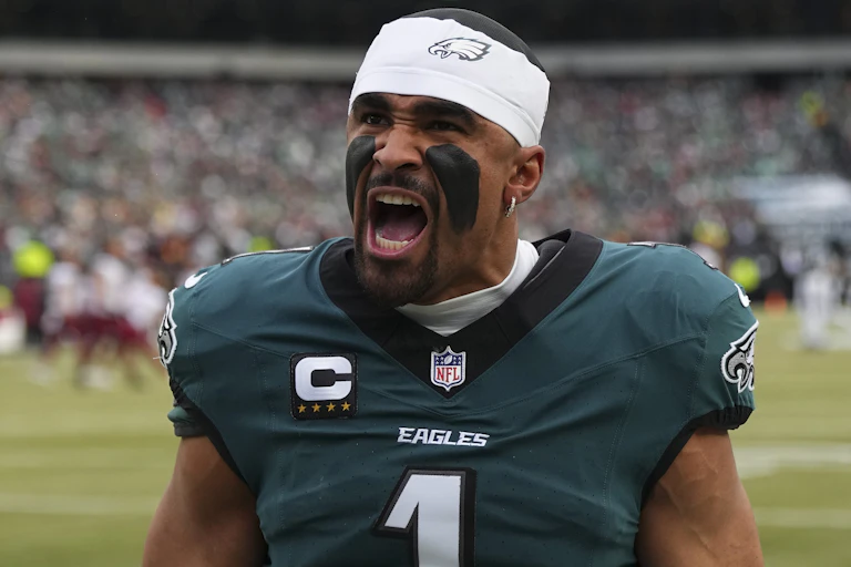Football player in green Eagles jersey screams on field in stadium