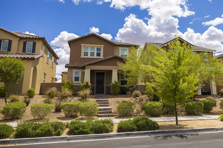 A row of new homes with desert rock landscapes in place of grass.