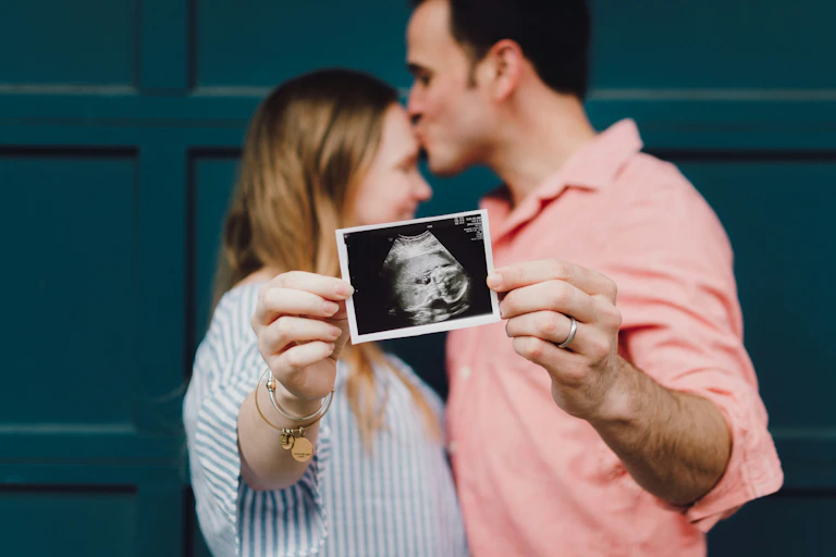 Un couple tenant une échographie de leur futur bébé.