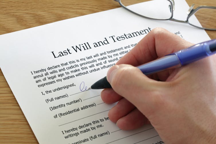 An unidentified hand signing a document