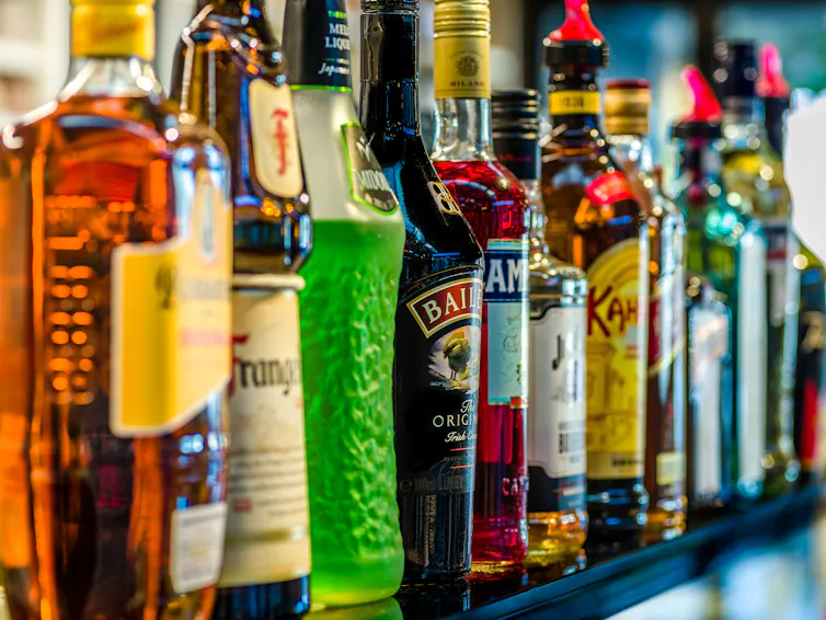 A row of liquor bottles on a shelf.