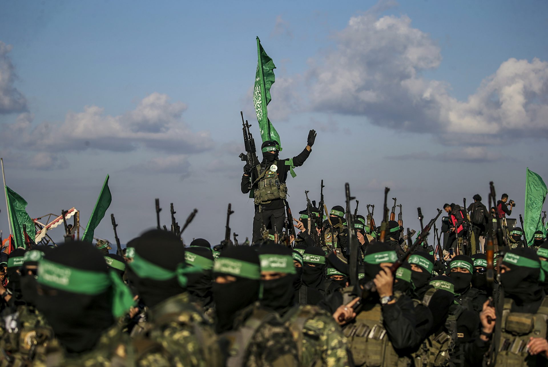 Hamas fighters wearing black face coverings and carrying guns.
